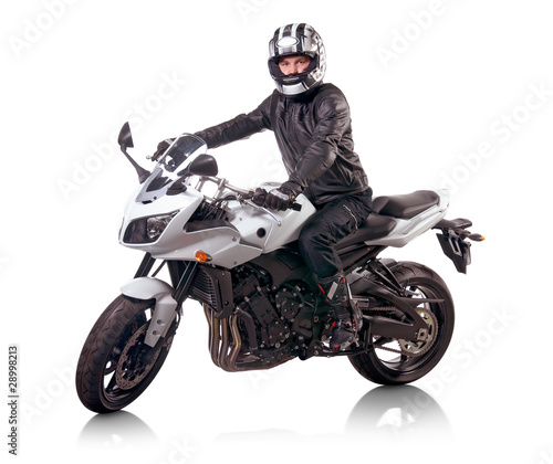 Foto: Biker in black leather jacket rides a white motorcycle Biker in black leather jacket rides a white motorcycle