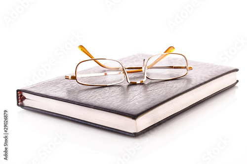 Photo: Notebook with glasses isolated on white Notebook with glasses isolated on white