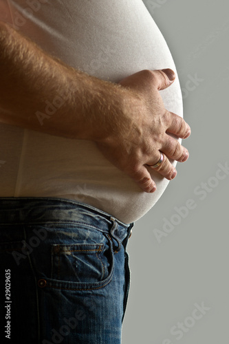 Photo: Overweight man with hand on belly Overweight man with hand on belly