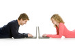 Attractive teenagers lying down using lap tops