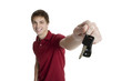 Attractive teenage boy holding car keys isolated on white backgr