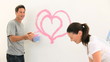 Smiling couple laughing while they are painting