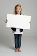Cute little girl isolated on neutral background holding sign