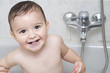 Niño pequeño disfrutando alegremente del baño diario.