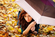 Girl is lying on autumn leaves with umbrella Girl is lying on autumn leaves with umbrella