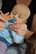Baby bekommt zum ersten Mal die Fingernägel geschnitten