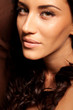Portrait of beautiful young brunette woman with curly hair
