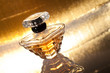 Perfume with reflection on gold background