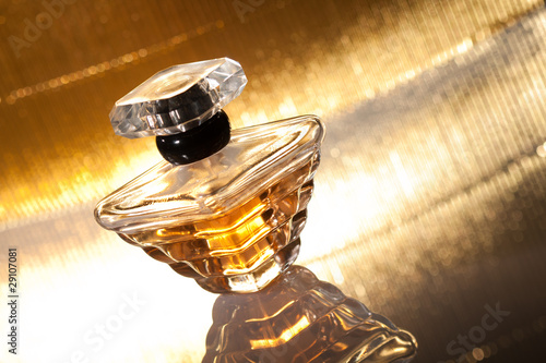 Photo: Perfume with reflection on gold background Perfume with reflection on gold background