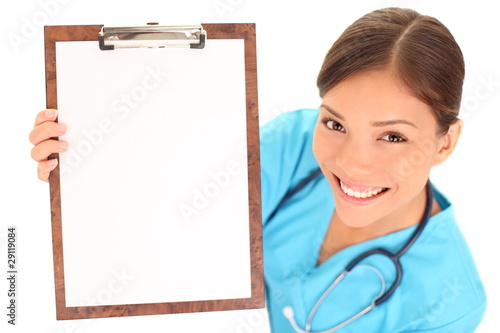 Photo: Nurse / doctor showing blank clipboard sign Nurse / doctor showing blank clipboard sign