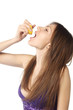 woman pouring juice from lemon slice in her mouth