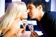 Young happy amorous couple with champagne kissing at party