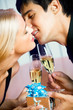 Young happy amorous couple with champagne and gift, kissing Young happy amorous couple with champagne and gift, kissing