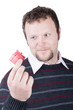 Young man holding valentine gift in his hand. He is giving it so Young man holding valentine gift in his hand. He is giving it so