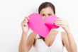 Photo: Young woman pulling paper heart to pieces Young woman pulling paper heart to pieces