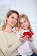 Little girl offering present to her mom
