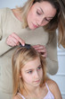 Photo: Mother treating daughter's hair against lice Mother treating daughter's hair against lice