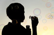 little boy inflating many soap bubbles silhouette, sky little boy inflating many soap bubbles silhouette, sky