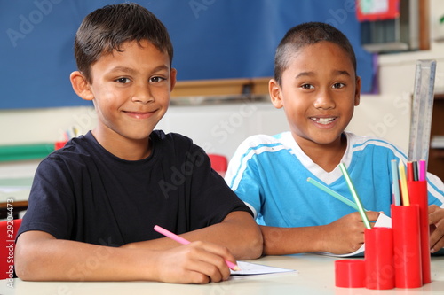 Photo: Two happy school boys sitting to their desk in class Two happy school boys sitting to their desk in class