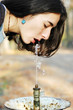 A beautiful girl drinks from a public drinking fountain A beautiful girl drinks from a public drinking fountain