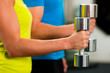 Paar mit Hanteln im Fitnessstudio