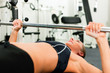 Frau im Fitnessstudio trainiert mit Langhantel
