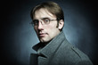 Photo: Artistic dark portrait of the young beautiful man in a gray coat Artistic dark portrait of the young beautiful man in a gray coat