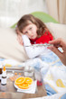 Clinical thermometer in hand showing fever and little sick girl