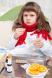 Little sick girl with scarf in bed is taking medicine