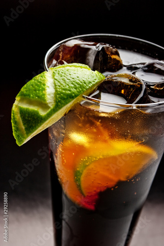 Photo: cold tea with lime and ice (close up) on dark background cold tea with lime and ice (close up) on dark background