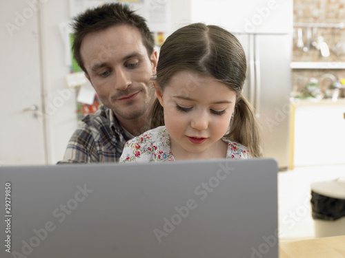 Photo: Girl 3-6 using laptop with father at home Girl 3-6 using laptop with father at home