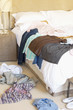 Clothes scattered on Floor and Bed of hotel room