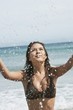 Young Woman Splashing in Surf at Beach