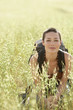 Female hiker squatting in long grass, portrait