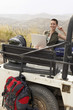 Photo: Woman using laptop sitting in back of four wheel drive car, in desert, portrait Woman using laptop sitting in back of four wheel drive car, in desert, portrait