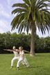 Middle-aged couple doing tai chi in park