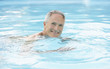 Middle-aged man swimming in pool, portrait