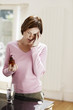 Woman with headache holding pills, touching head