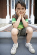Sad little boy sitting on front steps of house