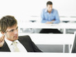 Businessman at desk contemplating in front of computer