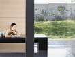 Photo: Young woman lying down using laptop indoors, portrait Young woman lying down using laptop indoors, portrait