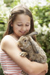 Girl in backyard holding bunny rabbit