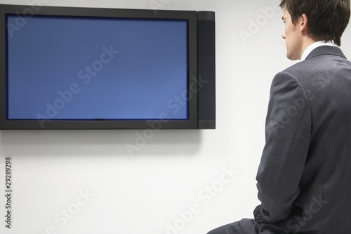 Photo: Businessman Looking at Flat Panel Television Businessman Looking at Flat Panel Television