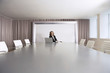 Female Business Executive Sitting in Boardroom with Laptop
