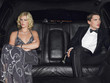 Couple in evening wear in back of car
