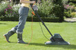 Woman Mowing Lawn With electric Lawn Mower