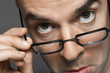 Balding man hand on glasses, making a face, close-up