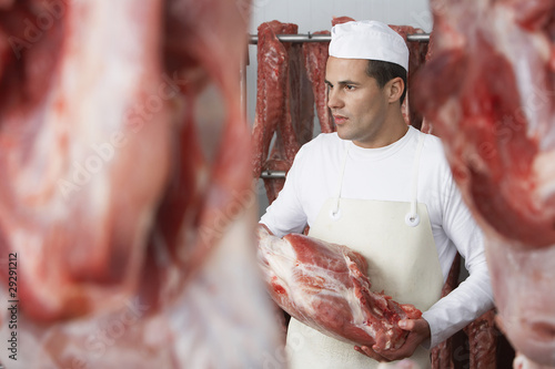 Photo: Butcher holding slab of meat, Working in Meat Locker Butcher holding slab of meat, Working in Meat Locker