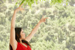 Woman dancing outdoors, side view.
