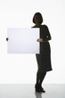 Silhouetted woman standing, holding large blank card to side